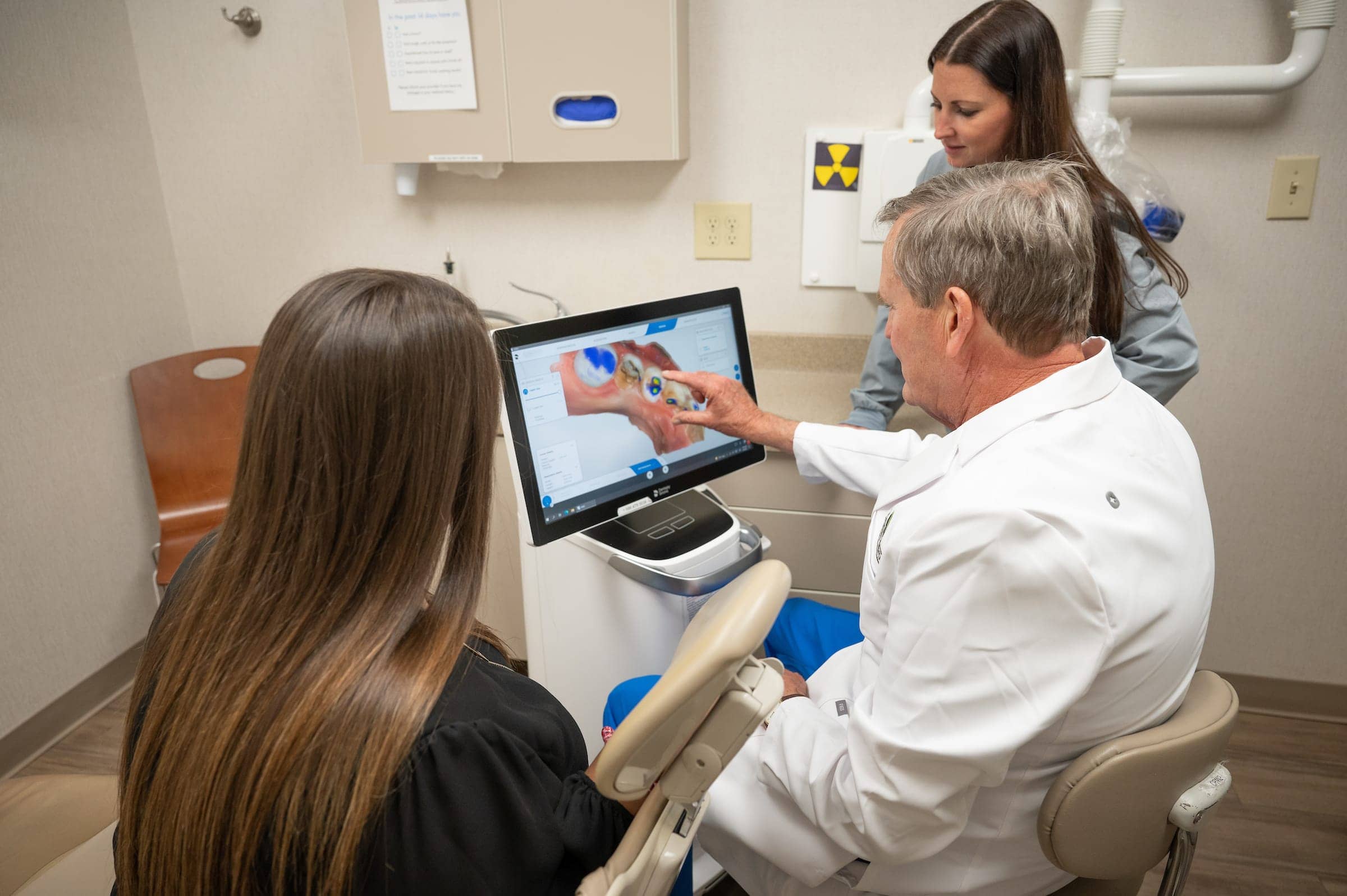 Dr Bill Cranford reviewing dental crowns with hygienists