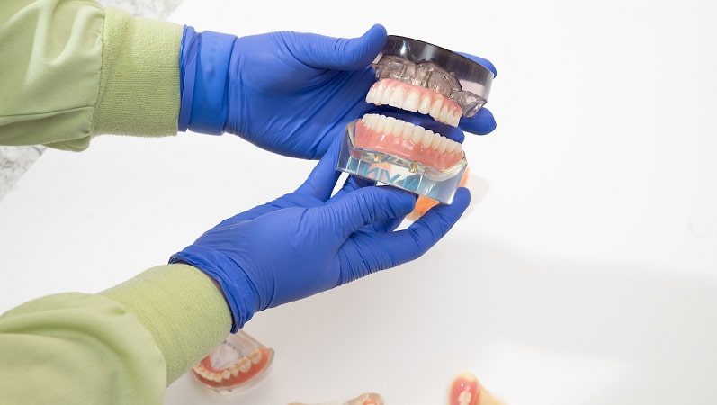 Hand holding quality denture