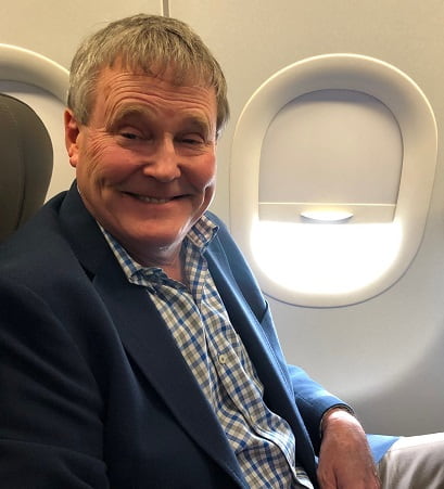 Dr. Bill Cranford smiling in airplane seat